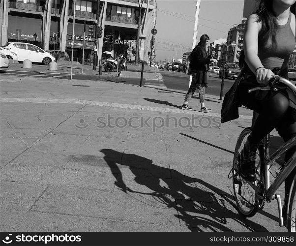 TURIN, ITALY - CIRCA FEBRUARY 2019: Pedestrian and woman on bike in the city centre in black and white. Pedestrian and bike in Turin in black and white