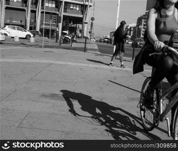 TURIN, ITALY - CIRCA FEBRUARY 2019: Pedestrian and woman on bike in the city centre in black and white. Pedestrian and bike in Turin in black and white