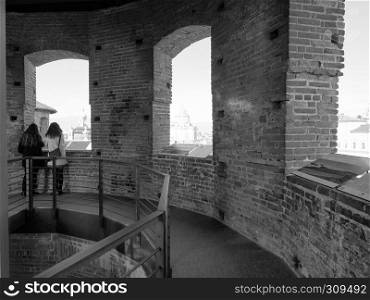 TURIN, ITALY - CIRCA FEBRUARY 2019: Women looking at the city from viewing platform on top of medieval tower in Piazza Castello in black and white. Women looking at the city from viewpoint in Turin in black and white