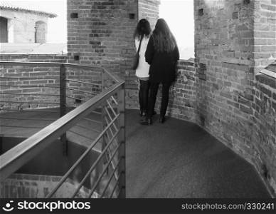 TURIN, ITALY - CIRCA FEBRUARY 2019: Women looking at the city from viewing platform on top of medieval tower in Piazza Castello in black and white. Women looking at the city from viewpoint in Turin in black and white