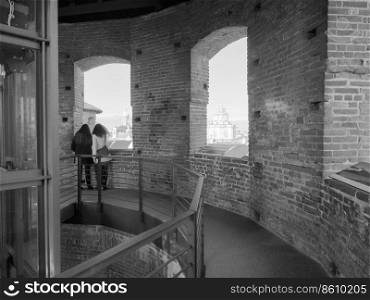 TURIN, ITALY - CIRCA FEBRUARY 2019  Women looking at the city from viewing platform on top of medieval tower in Piazza Castello in black and white. Women looking at the city from viewpoint in Turin in black and white