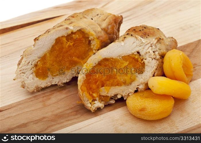 turkey breast rolls cooked with apricots, cut on wooden board