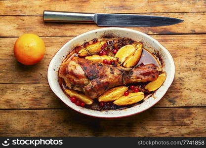 Turkey meat baked in oranges. Roasted turkey leg on rustic wooden table. Baked turkey meat with citrus fruit