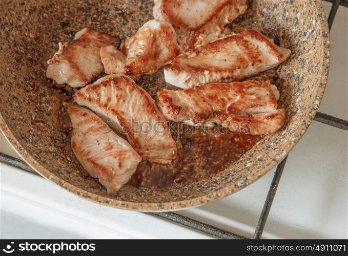 Turkey steak frying on pan top view