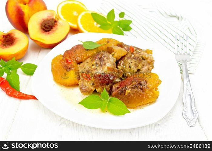 Turkey stewed with peaches, fresh hot pepper and orange sauce, basil leaves in a plate, napkin, fruits on white wooden board background