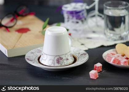Turkish Coffee in White Porcelain Cup and Turkish Delight.Single overturned coffee cup on the plate for coffee divination