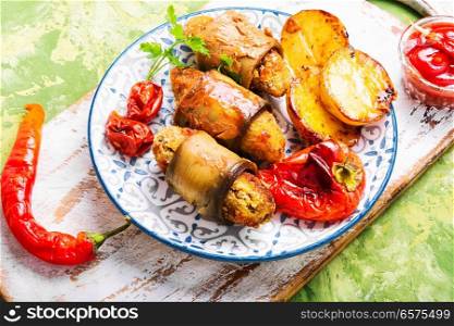 Turkish cuisine, meat fingers in eggplant rolls. Turkish dish of eggplant parmak-koft