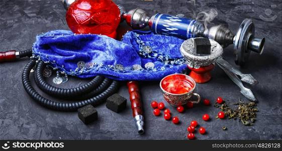 Turkish hookah with fruit. Turkish hookah and tea with berries on a stone background