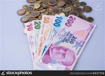 Turkish Lira coins and banknotes side by side on white background