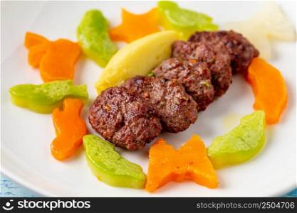 Turkish meatball traditional kofte. with carrots and zucchini cut into animal shapes. Spicy Meatballs Kebab or Kebab
