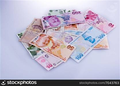 Turksh Lira banknotes of various color, pattern and value on white background