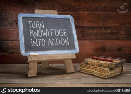 turn knowledge into action - motivational advice on a vintage slate blackboard in a retro classroom
