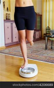 turn the feet of a woman standing on bathroom scales to