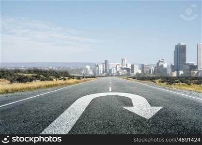 Turning sign on road. Natural landscape of asphalt road and drawn turn arrow