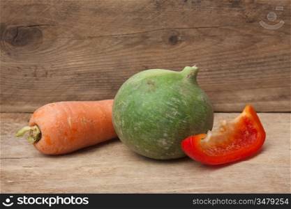 turnip, pepper and carrot on a wooden background