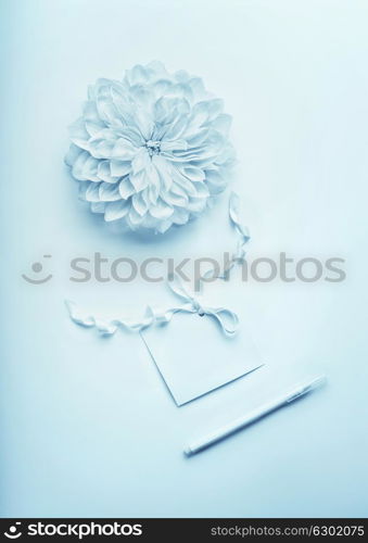 Turquoise blue mock up composition with flower, blank paper card with ribbon and pencil , flat lay, top view. Mock up for greeting of Mothers day, birthday, Valentine's Day, wedding or happy event