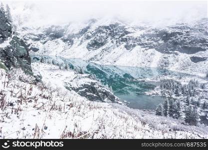 Turquoise mountain lake. Winter and snow in mountain valley.