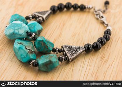 Turquoise with black onyx bead bracelet on wooden floor