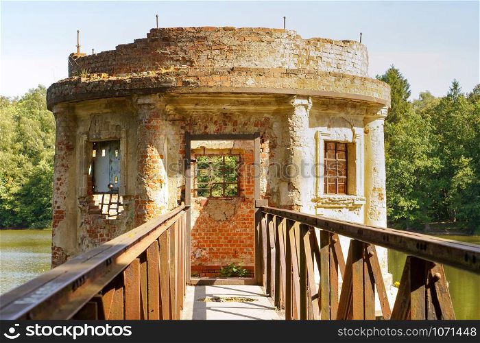 turret with a shutter on a forest pond, an old abandoned structure on a pond, vilgeiten pond, kolosovka village, Zelenograd city district, Kaliningrad region, Russia, August 18, 2019. an old abandoned structure on a pond, turret with a shutter on a forest pond