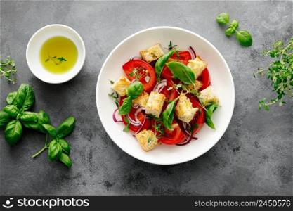 Tuscan Panzanella salad with tomatoes, basil and bread, top view