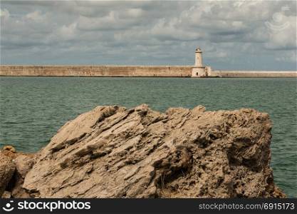 Tuscany Coastline: White Lighthouse Tower, Cliffs and Stone Jetty near Sea, Italy