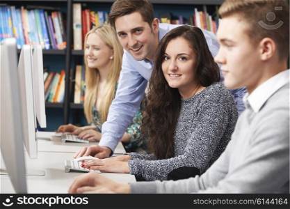 Tutor Helping Students Working At Computer