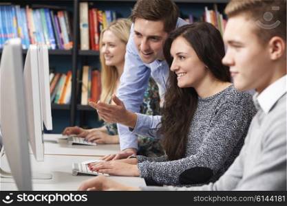 Tutor Helping Teenage Students Working At Computers