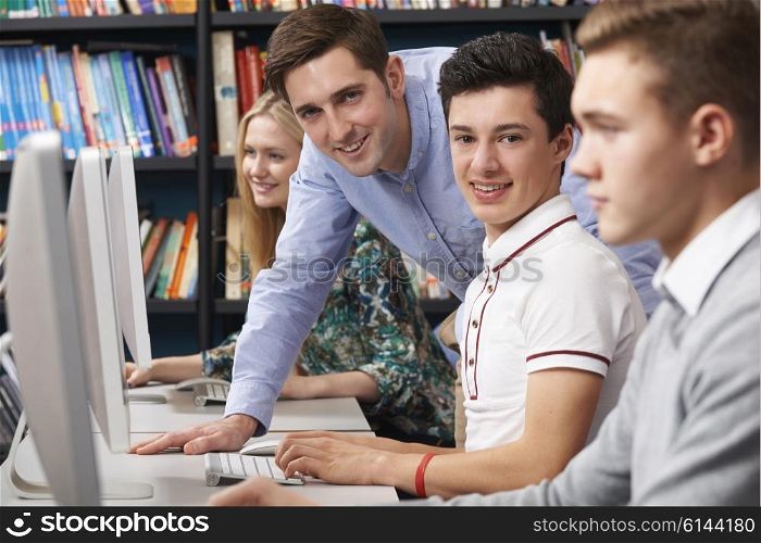 Tutor Helping Teenage Students Wotking At Computers