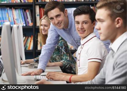 Tutor Helping Teenage Students Wotking At Computers