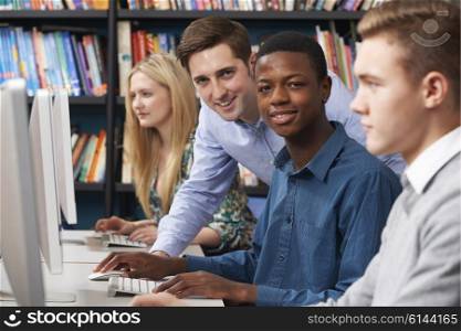 Tutor With Group Of Teenage Students Using Computers