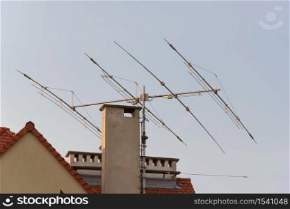 Tv antenna on roof of home. Technology of broadcast television and radio on rooftop. Signal receiver. Tower of transmit media. Residential roofing with mast of analogue antena. urban Photography