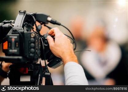 TV camera at a press conference, capturing a video of an unrecognizable speaker which are then broadcasted on television or streamed online. . TV Camera at a Press Conference