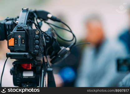 TV camera at a press conference, capturing a video of an unrecognizable speaker which are then broadcasted on television or streamed online. . TV Camera at a Press Conference