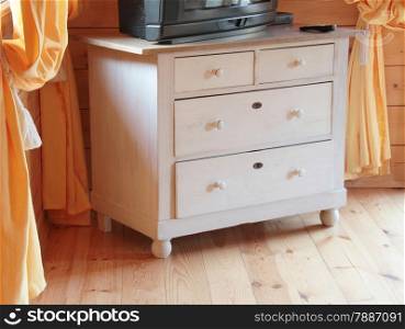 TV set on the wooden dresser in a bright room