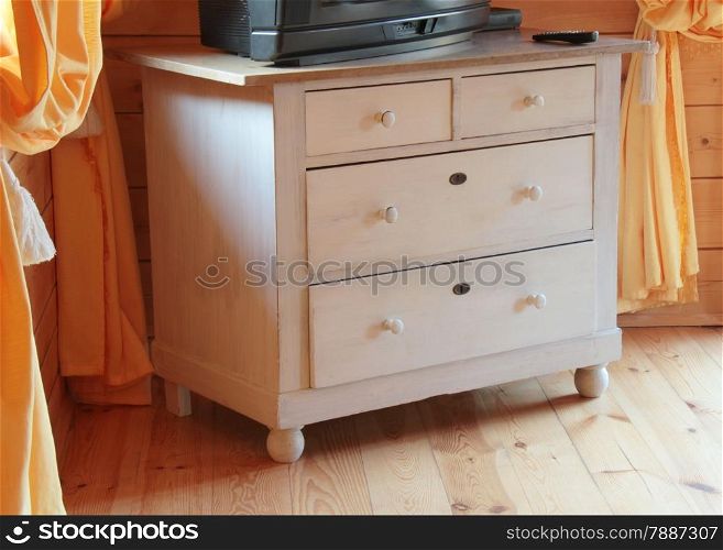 TV set on the wooden dresser in a bright room