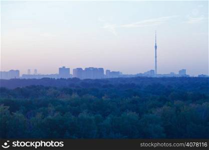 TV tower and urban houses in early blue dawn in summer morning, Moscow