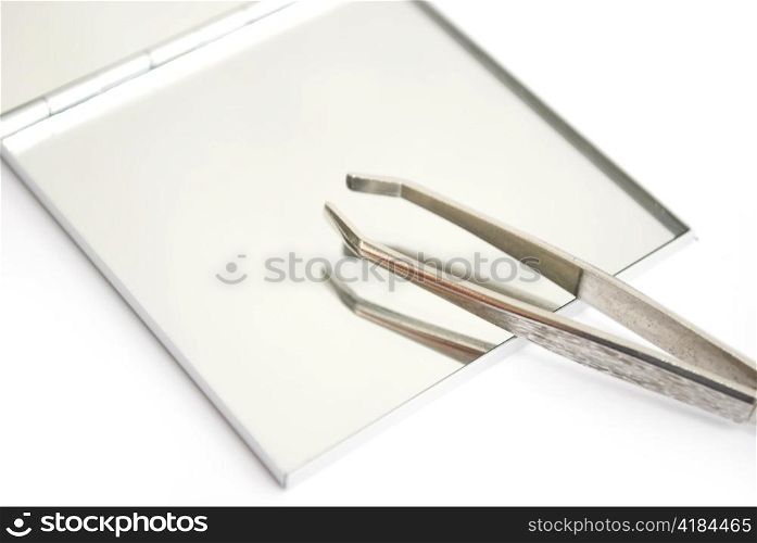 tweezers and mirror isolated on white