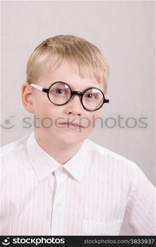Twelve year old boy in glasses looking into the frame