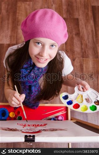 Twelve year old girl draws a picture on the easel