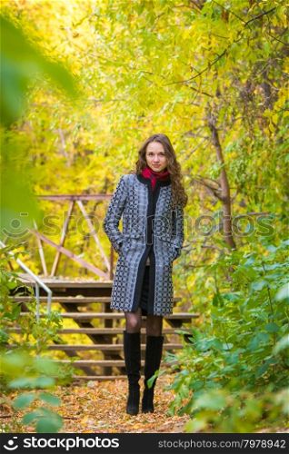 Twenty-five young beautiful girl walks by Europeans autumn forest. Girl walks in the warm autumn weather