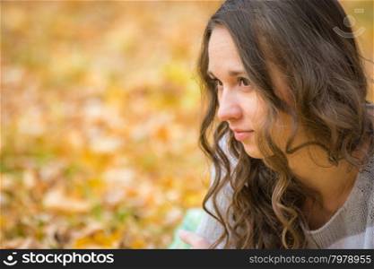 Twenty-five young beautiful girl walks by Europeans autumn forest. Close-up portrait of a beautiful young girl looking to the left
