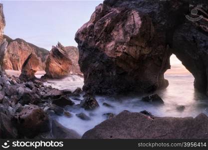 Twilight at rocky coastline of Atlantic ocean, Ursa beach, Portugal