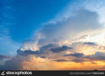 Twilight blue bright and orange yellow dramatic sunset sky in countryside or beach colorful cloudscape texture with white clouds air background.