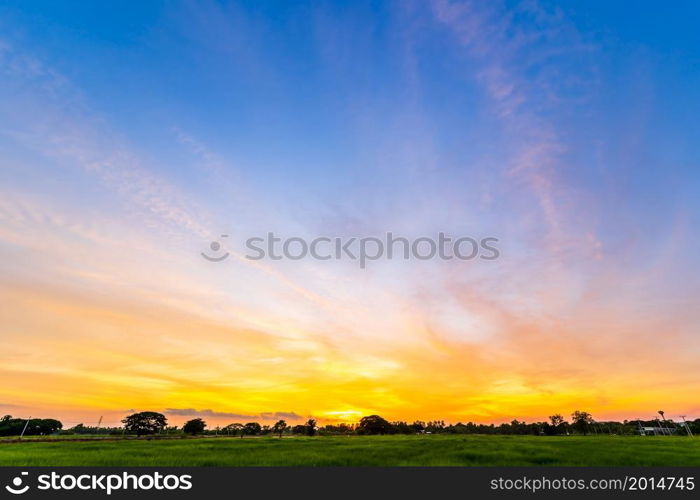 Twilight blue bright and orange yellow dramatic sunset sky in countryside or beach colorful cloudscape texture with white clouds air background.