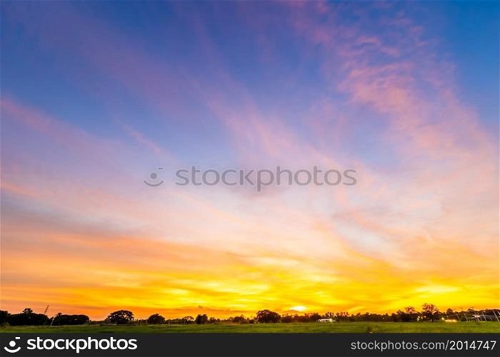 Twilight blue bright and orange yellow dramatic sunset sky in countryside or beach colorful cloudscape texture with white clouds air background.
