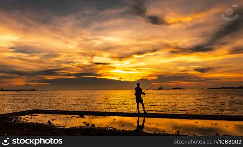 twilight seascape the sunset and light gold with fisherman silhouette foreground on island in Thailand