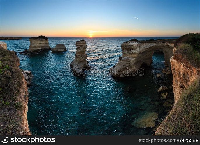 Twilight seascape with cliffs, rocky arch and stacks (faraglioni), at Torre Sant Andrea, Salento sea coast, Puglia, Italy