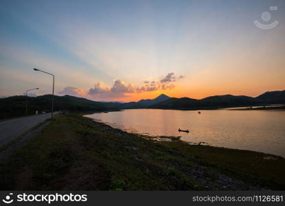 twilight sky river sunset blue and orange color landscape lake evening time clouds and silhouette mountains background