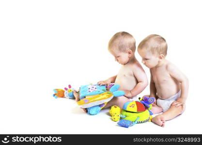 Twin baby boys are plaing together. Studio shot. All toys visible on the photo are officialy property released.