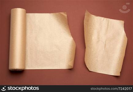 twisted roll of brown parchment paper on a brown background, wax baking paper, top view